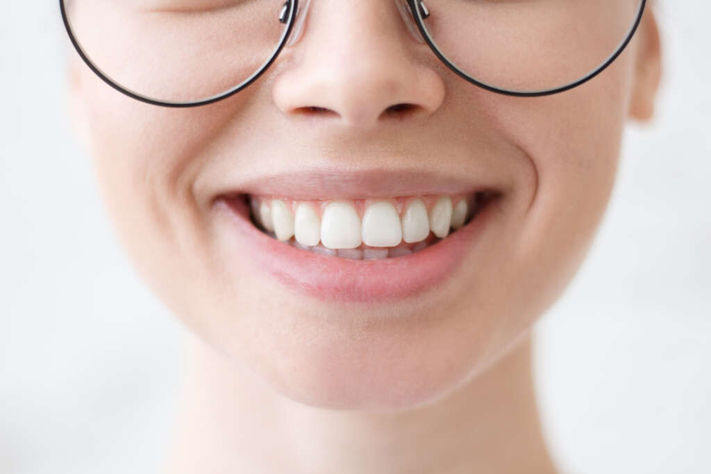 Close up shot of young beautiful woman toothy smile